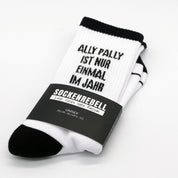 SOCKENREBELL black and white socks with "ALLY PALLY IST NUR EINMAL IM JAHR" text. Cotton blend.