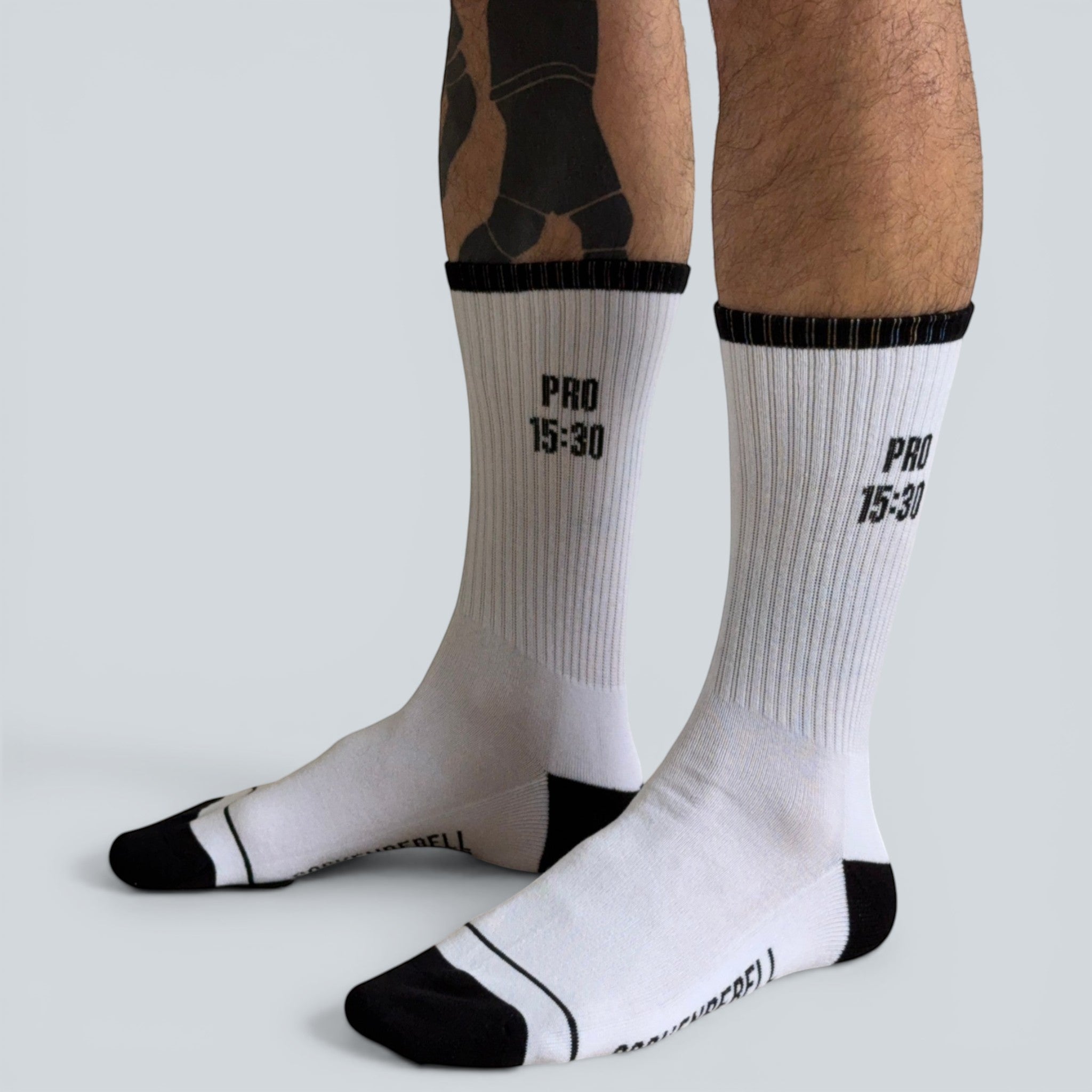 SOCKENREBELL PRO 15:30 white crew socks with black toe and heel accents, ribbed cuffs, and text.