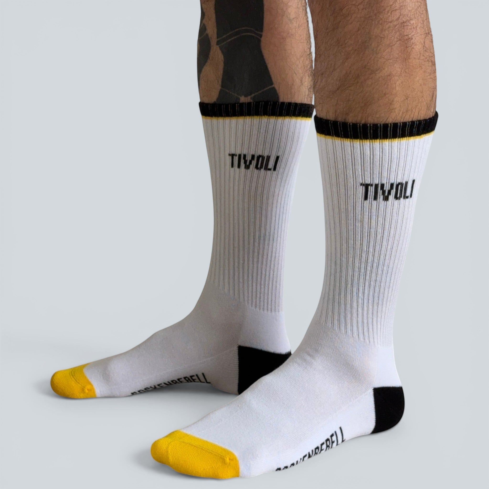SOCKENREBELL white crew socks with black and yellow accents and TIVOLI logo. Made from cotton blend.