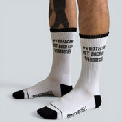 SOCKENREBELL white crew socks with black trim and toe, featuring the text "PYROTECHNIK IST DOCH KEIN VERBRECHEN" in black.