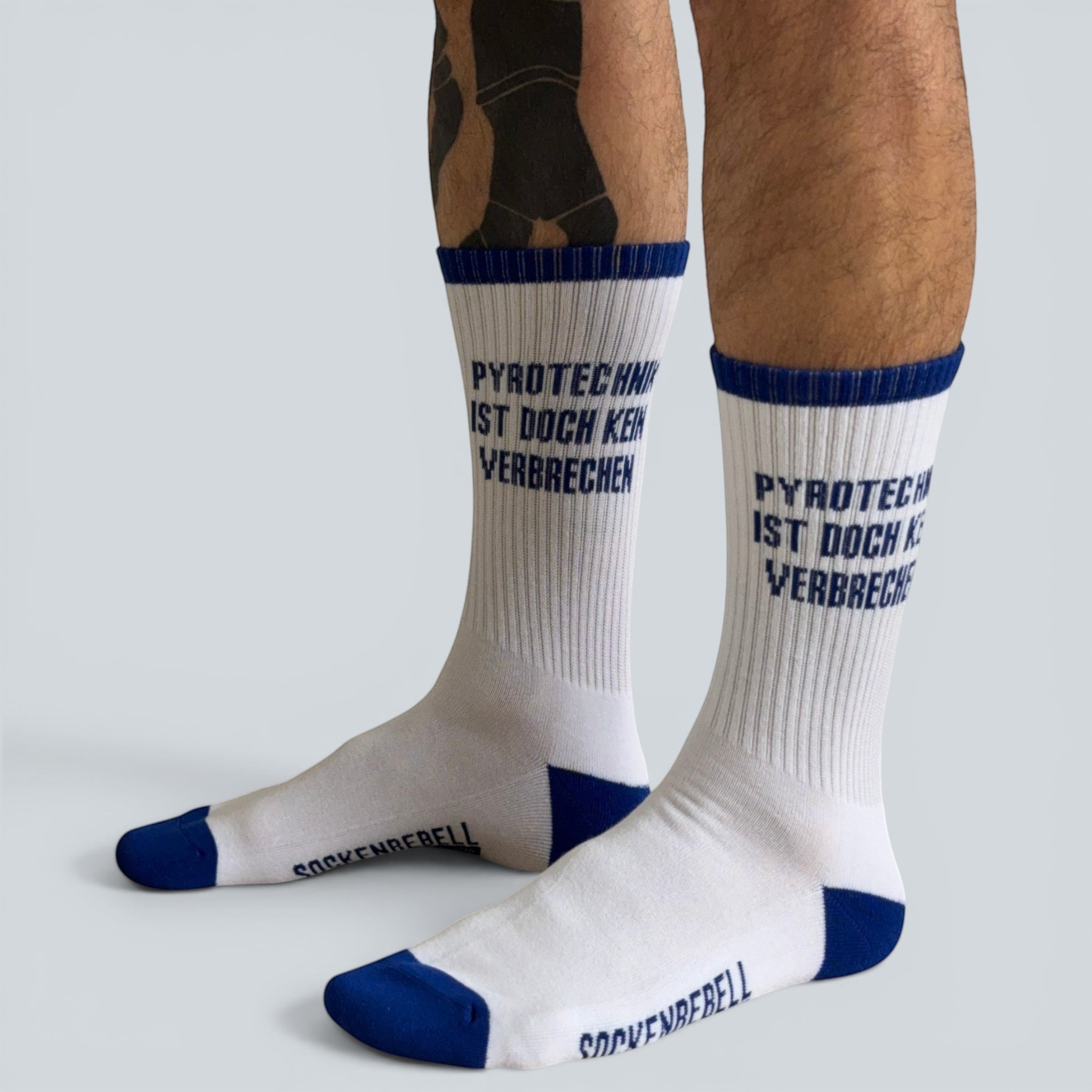 SOCKENREBELL white crew socks with blue trim and text "PYROTECHNIK IST DOCH KEIN VERBRECHEN".