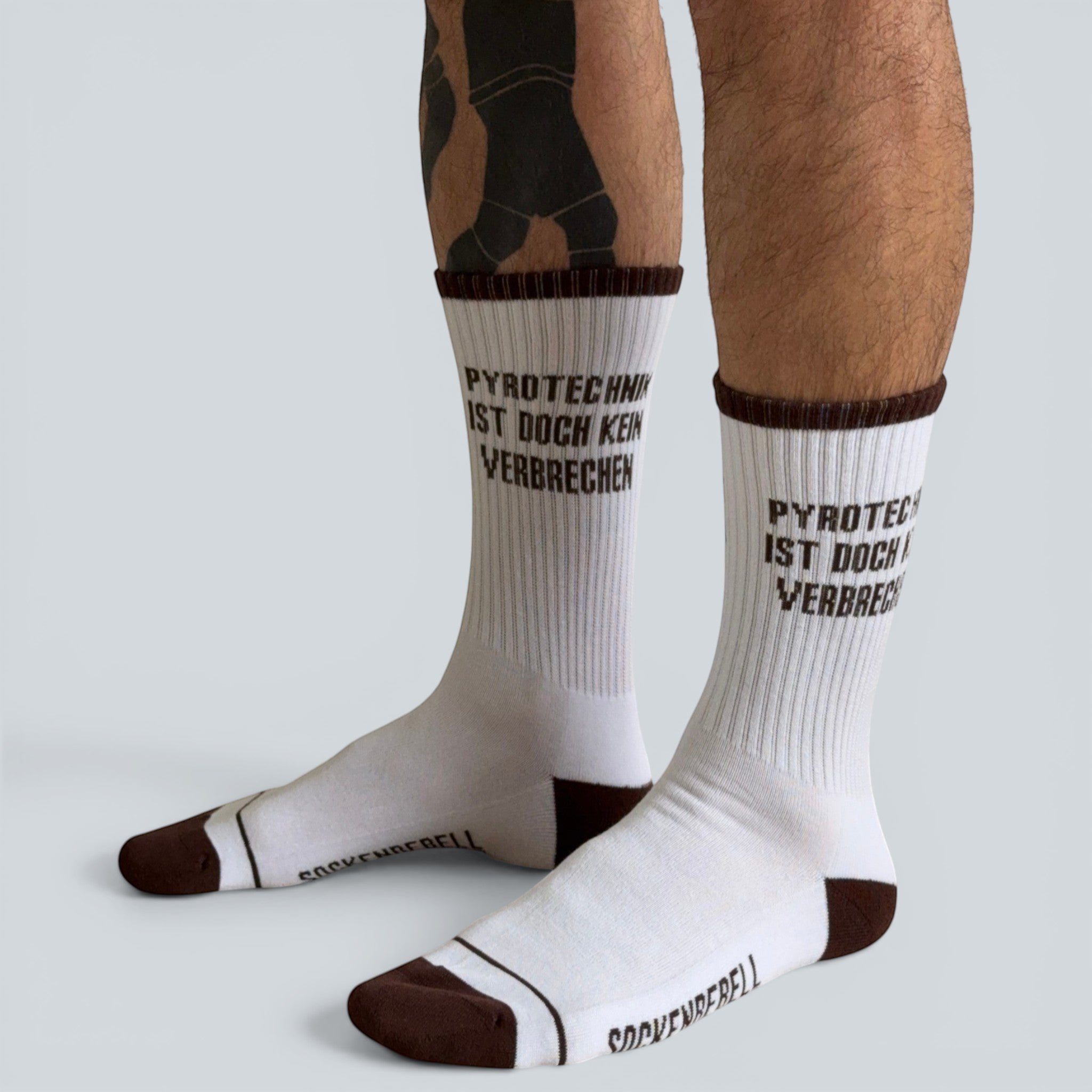 SOCKENREBELL white and brown crew socks with "PYROTECHNIK IST DOCH KEIN VERBRECHEN" text. Cotton blend.