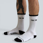 SOCKENREBELL white crew socks with black trim, toe, heel, and "FUCK YOU" text.