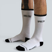 SOCKENREBELL white crew socks with black trim and toe, featuring "SPIELTAG" text. Made from cotton blend.